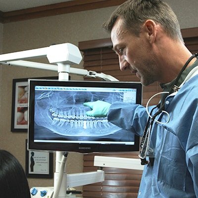 Dr. Godwin showing patient their x-rays as part of periodontal treatment.